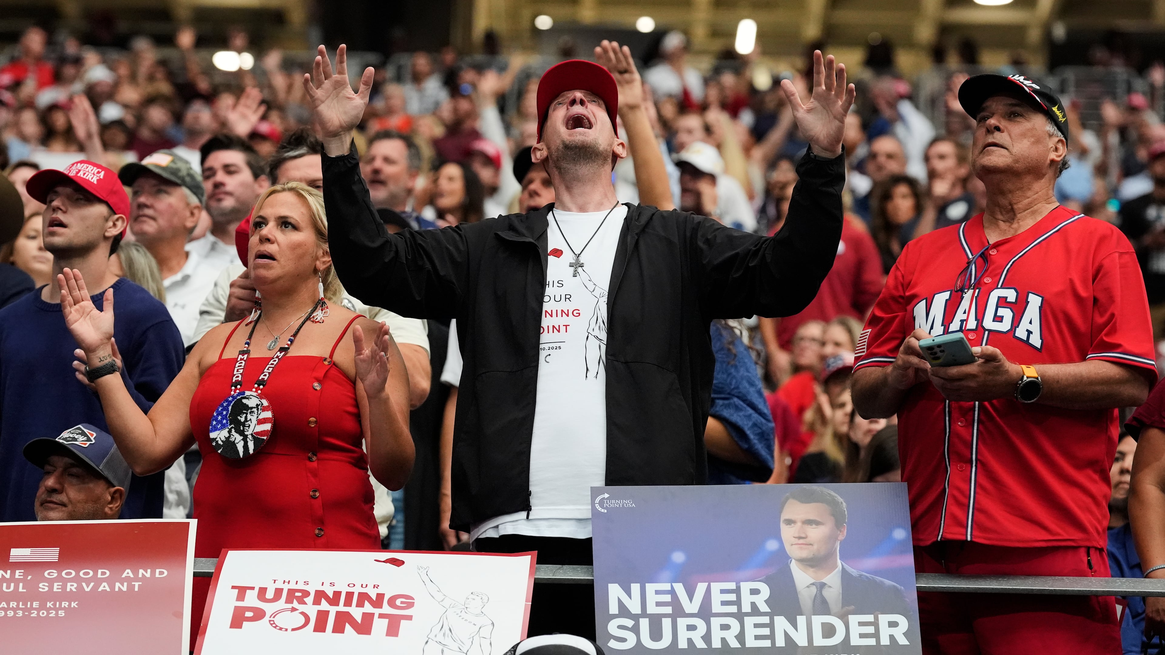 A man listens during a worship song before the start of a memorial for conservative activist Charlie Kirk, Sunday, Sept. 21, 2025, at State Farm Stadium in Glendale, Ariz. (AP Photo/Ross D. Franklin)