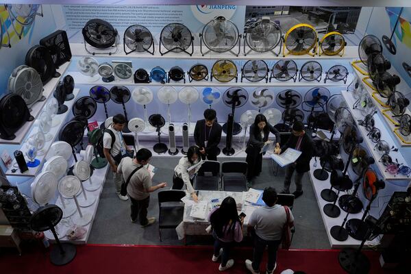 Visitors look at fans displayed at the 137th Canton Fair in Guangzhou in southern China's Guangdong province, Tuesday, April 15, 2025. (AP Photo/Ng Han Guan)