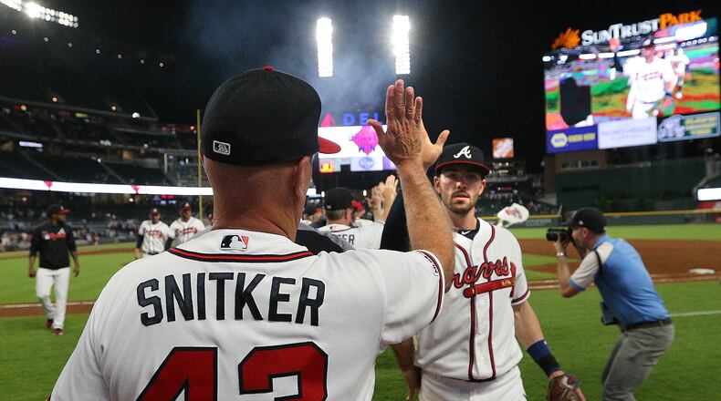 Braves manager Brian Snitker gives Dansby Swanson five after a 5-1 victory over the San Diego Padres on Wednesday, May 1, 2019, in Atlanta.