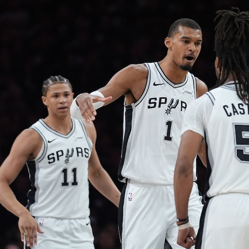 San Antonio Spurs forward Victor Wembanyama (1) celebrates a score with guard Stephon Castle (5) during the first half of Game 6 of an NBA basketball second-round playoffs series in Minneapolis, Friday, May 15, 2026. (AP Photo/Abbie Parr)