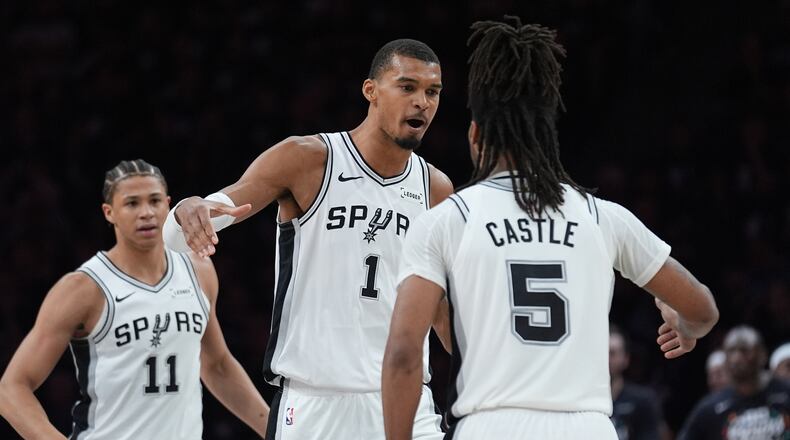 San Antonio Spurs forward Victor Wembanyama (1) celebrates a score with guard Stephon Castle (5) during the first half of Game 6 of an NBA basketball second-round playoffs series in Minneapolis, Friday, May 15, 2026. (AP Photo/Abbie Parr)