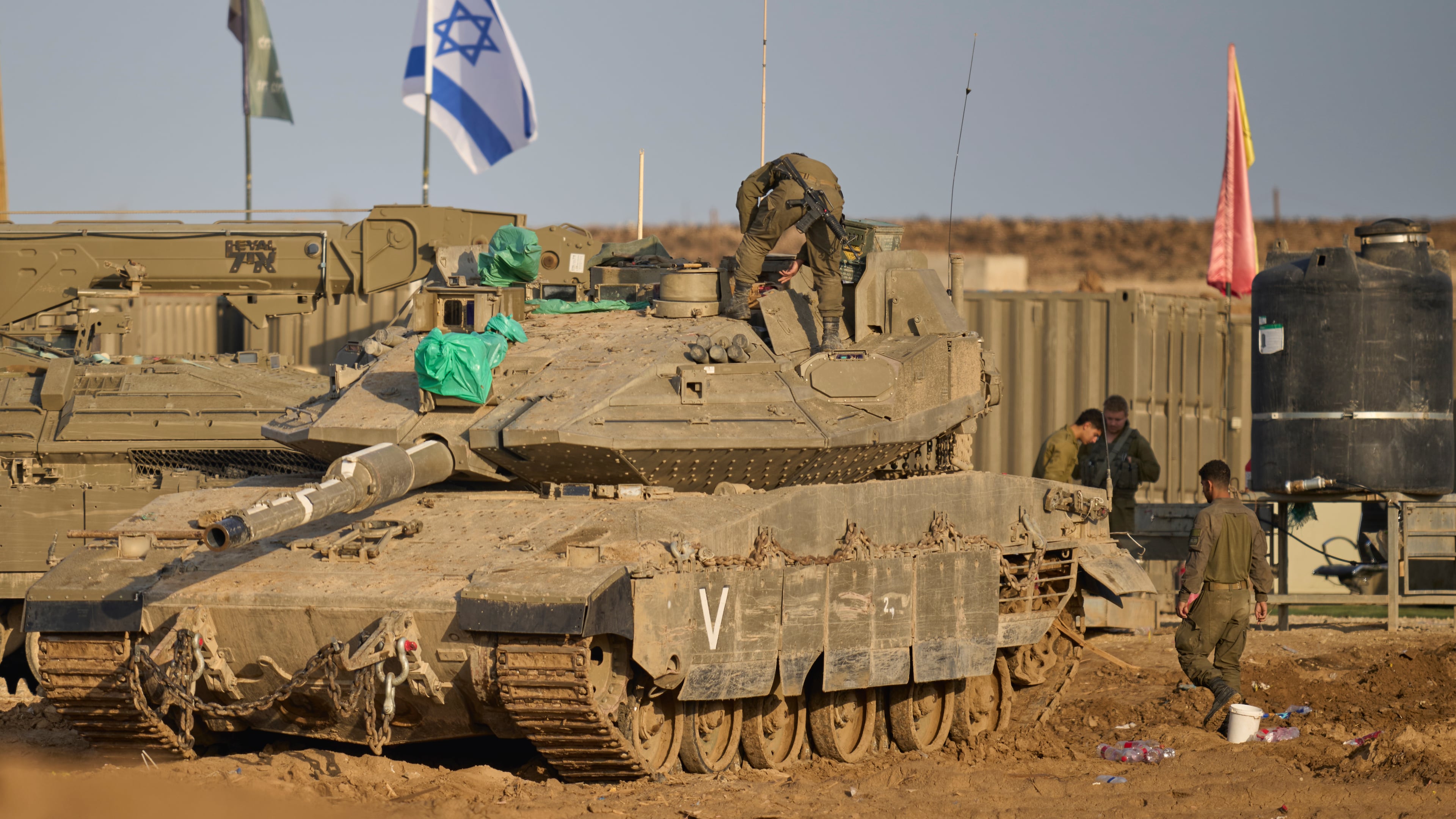 Israeli soldiers work on tanks at a staging area on the border with Gaza Strip, in southern Israel, Tuesday, Nov. 18, 2025. (AP Photo/Ohad Zwigenberg)
