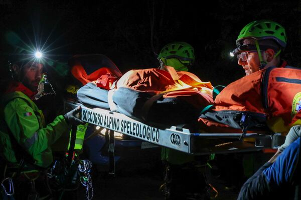Rescuers recoup the body of one of the victims of a cable car carrying tourists south of Naples which crashed after the cable snapped, killing at least four people and injuring one in Castellamare di Stabia, near Naples, Italy, Thursday, April 17, 2025. (AP Photo/Salvatore Laporta)