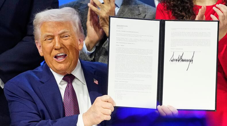President Donald Trump holds the charter during a signing ceremony on his Board of Peace initiative at the Annual Meeting of the World Economic Forum in Davos, Switzerland, Thursday, Jan. 22, 2026. (AP Photo/Markus Schreiber)