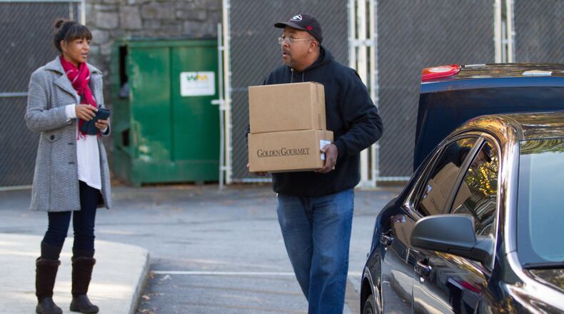 Volunteer Rodney Cheek helps to load cars with box dinners for Meals On Wheels in 2018. STEVE SCHAEFER / SPECIAL TO THE AJC