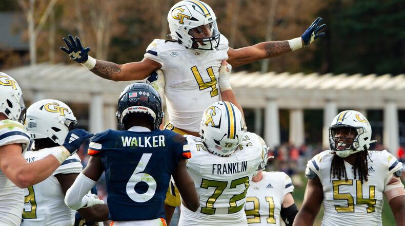 Georgia Tech running back Dontae Smith (4) is lifted in the air by offensive lineman Weston Franklin (72) after scoring a touchdown against Virginia during the second half of an NCAA college football game Saturday, Nov. 4, 2023, in Charlottesville, Va. (AP Photo/Mike Caudill)