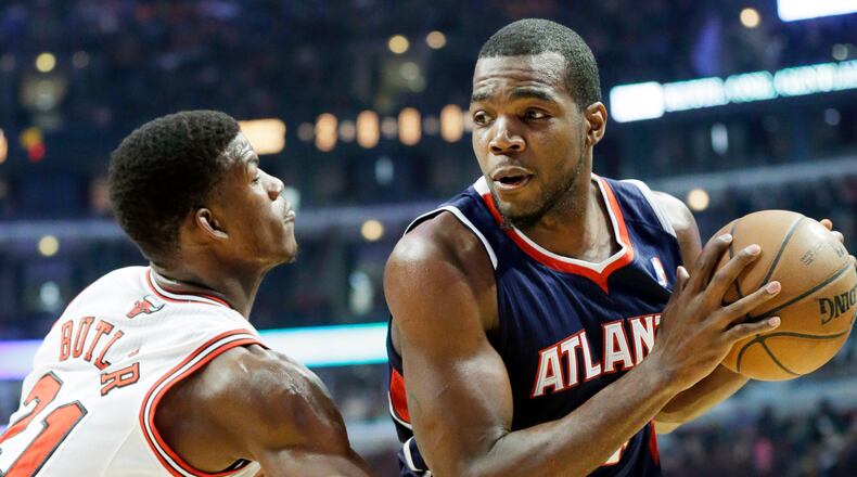Atlanta Hawks forward Paul Millsap, right, looks to pass as Chicago Bulls guard Jimmy Butler defends during the first half of an NBA basketball game in Chicago on Saturday, Jan. 4, 2014. (AP Photo/Nam Y. Huh)