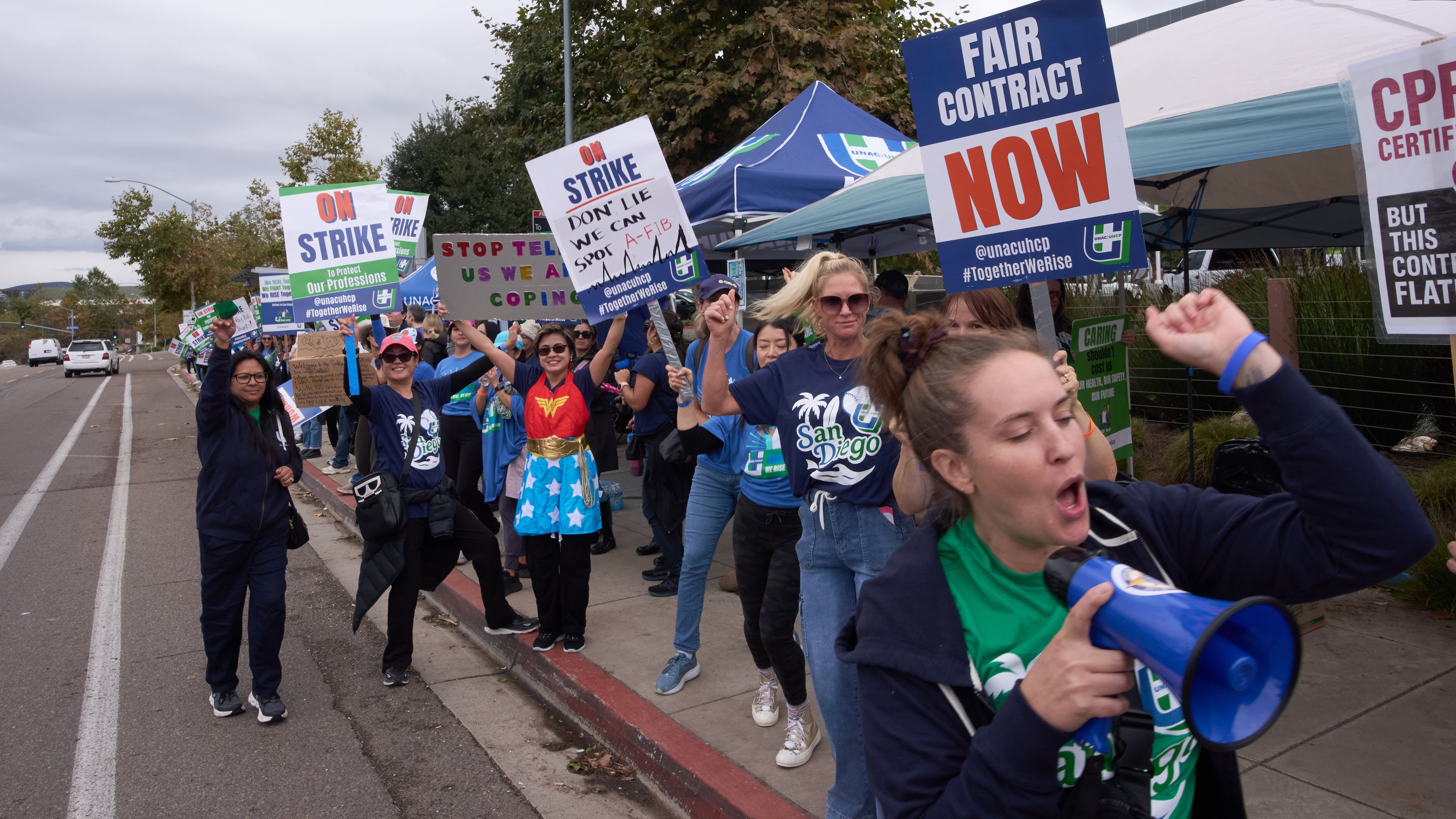 Kaiser Permanente health care workers hold signs and chant slogans while on strike in front of the Kaiser Permanente San Diego Medical Center Tuesday, Oct. 14, 2025, in San Diego. (AP Photo/Gregory Bull)