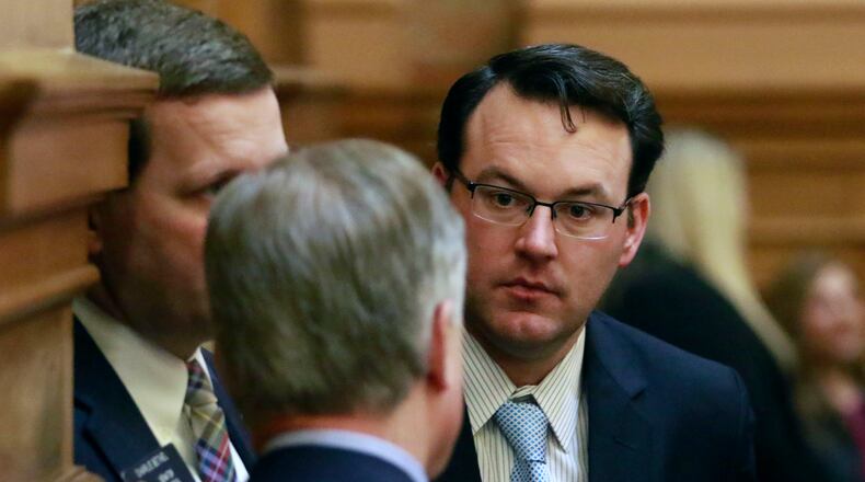 State Sen. Burt Jones confers with colleagues on the floor of the chamber. BOB ANDRES / BANDRES@AJC.COM