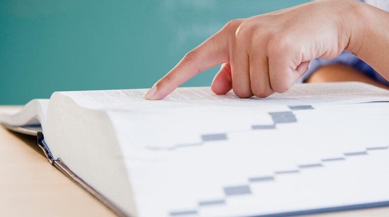 Finger pointing to word in dictionary