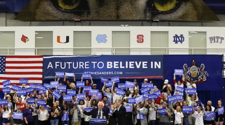 The eyes of the poster of the University of Pittsburgh panther are above supporters waving signs and cheering as Democratic presidential candidate Sen. Bernie Sanders, I-Vt., arrives for a campaign rally at Fitzgerald Fieldhouse on the University of Pittsburgh campus, Monday, April 25, 2016, in Pittsburgh. (AP Photo/Keith Srakocic)