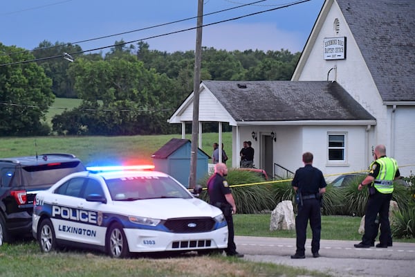 Police stand at the front of the Richmond Road Baptist Church as other officers maintain a perimeter following a shooting at the church in Lexington, Ky., Sunday, July 13, 2025. (AP Photo/Timothy D. Easley)