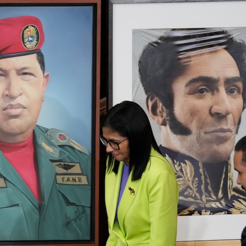 FILE - Venezuela's acting President Delcy Rodriguez walks past a image of former President Hugo Chavez, left, and Independence hero Simon Bolivar at the National Assembly in Caracas, Venezuela, Jan. 15, 2026. (AP Photo/Ariana Cubillos, File)