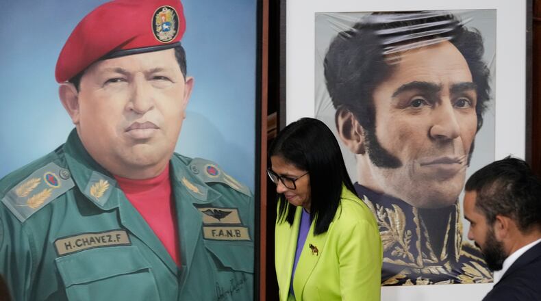 FILE - Venezuela's acting President Delcy Rodriguez walks past a image of former President Hugo Chavez, left, and Independence hero Simon Bolivar at the National Assembly in Caracas, Venezuela, Jan. 15, 2026. (AP Photo/Ariana Cubillos, File)