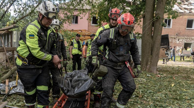 Rescuers carry a body that they removed from under the rubble of an apartment building following Russia's missile attack in Kharkiv, Ukraine, Saturday, June 20, 2026. (AP Photo/Andrii Marienko)