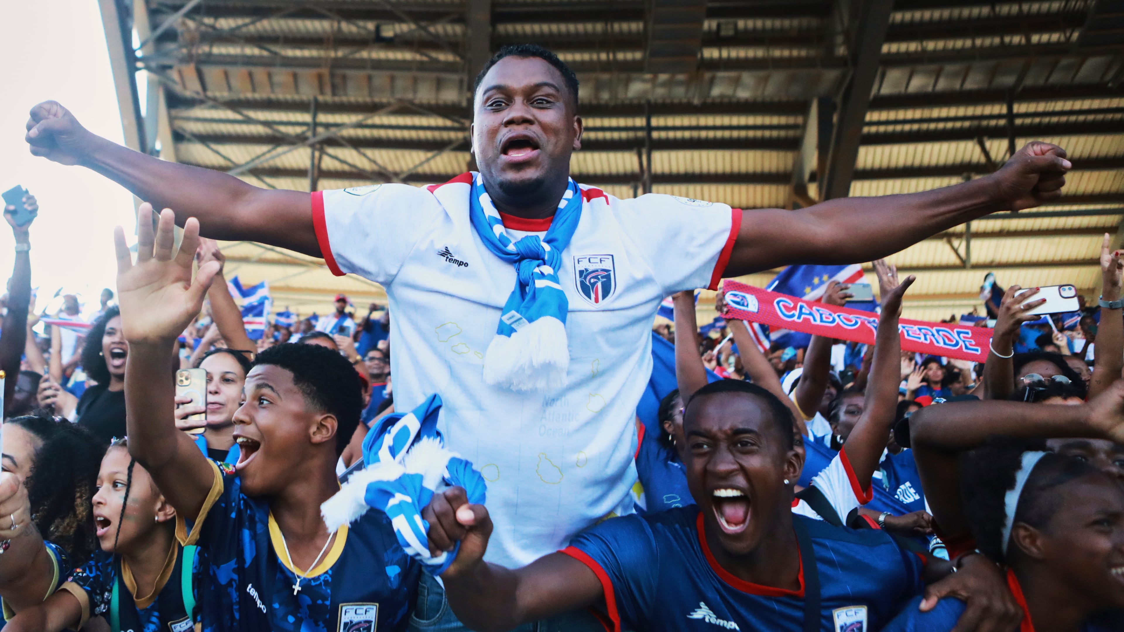 Fans celebrate in the stands after Cape Verde defeated Eswatini in a World Cup qualifying soccer match at Estádio Nacional in Praia, Cape Verde, Monday, Oct. 13, 2025, to clinch their qualification for the 2026 World Cup. (AP Photo/Cristiano Barbosa)