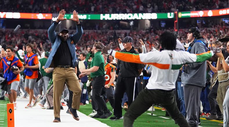 Former NFL football players Ray Lewis, left, and Michael Irvin react after Miami running back Charmar Brown, not visible, scored a rushing touchdown during the second half of the Cotton Bowl College Football Playoff quarterfinal game against Ohio State Wednesday, Dec. 31, 2025, in Arlington, Texas. (AP Photo/Julio Cortez)
