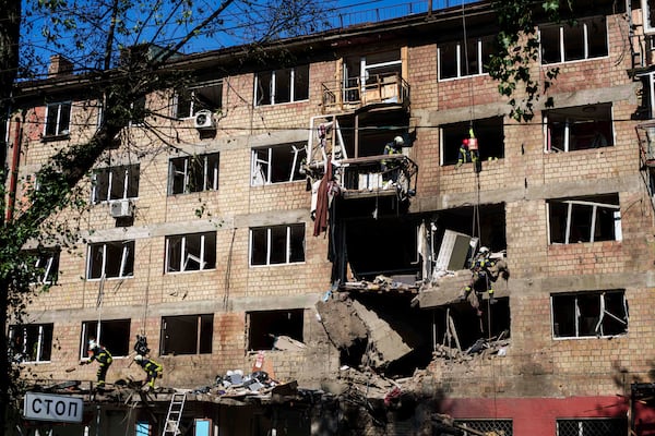 Rescue workers clear the rubble of a residential house damaged by a Russian strike in Kyiv, Ukraine, on Friday, July 4, 2025. (AP Photo/Evgeniy Maloletka)