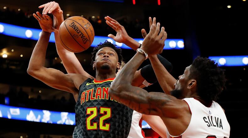 Hawks rookie Cam Reddish has the ball stripped by the Heat's Kelly Olynyk as he drives against Chris Silva Oct. 31, 2019, at State Farm Arena in Atlanta.
