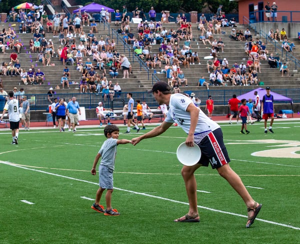 During halftime, fans, including 7-year-old Benjamin Litner, are allowed to come onto the field to toss a disc with the professionals. The Hustle, Atlanta's American Ultimate Disc League team, competed against Philadelphia at St. Pius X High School Field on Saturday, June 26, 2021.  Atlanta won the game 24-17. (Jenni Girtman for The Atlanta Journal-Constitution)