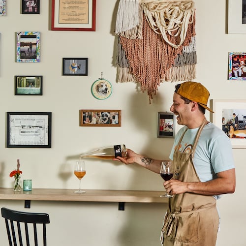 Little Bear chef and owner Jarrett Stieber pours a glass of wine in the restaurant. In June, he announced plans for a second restaurant, a wine bar called Bar Schmutzi coming to East Atlanta. (Bailey Garrot for the AJC)