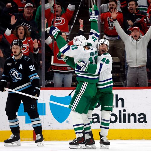 Carolina Hurricanes' Jordan Staal (11) is celebrates after his winning goal with teammate Jordan Martinook (48) with Utah Mammoth's Mikhail Sergachev (98) nearby during the third period of an NHL hockey game in Raleigh, N.C., Thursday, Jan. 29, 2026. (AP Photo/Karl DeBlaker)