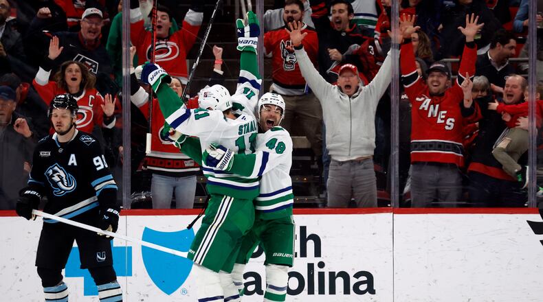 Carolina Hurricanes' Jordan Staal (11) is celebrates after his winning goal with teammate Jordan Martinook (48) with Utah Mammoth's Mikhail Sergachev (98) nearby during the third period of an NHL hockey game in Raleigh, N.C., Thursday, Jan. 29, 2026. (AP Photo/Karl DeBlaker)