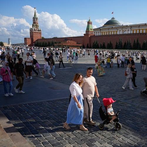 FILE - A family walks through Red Square in Moscow, Russia, Sunday, Aug. 4, 2024. (AP Photo/Alexander Zemlianichenko, File)