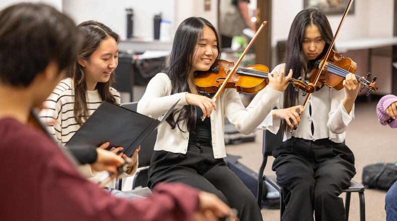 North Gwinnett High School students Claire Park and Jeanne Yoon, Kate Hwang practice in the orchestra room before a concert. They are members of Fine Arts for All, a student-led organization that strives to spread exposure to the fine arts to those who don't have access to them.  PHIL SKINNER FOR THE ATLANTA JOURNAL-CONSTITUTION