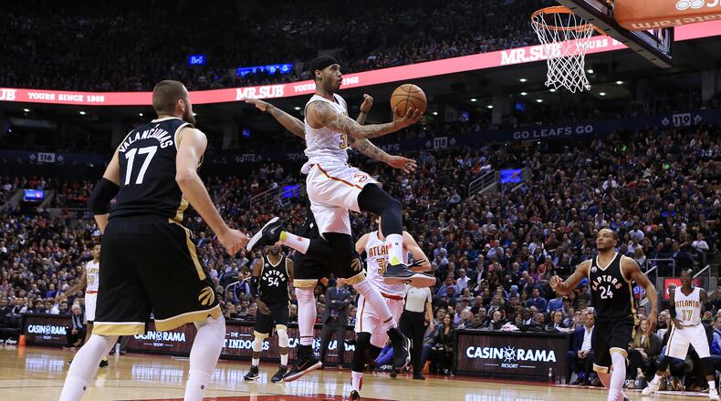 Mike Scott of the Atlanta Hawks drives to the basket as Jonas Valanciunas (17) and DeMar DeRozan (10) of the Toronto Raptors defend during the second half of an NBA game at the Air Canada Centre on March 30, 2016 in Toronto, Ontario, Canada. (Photo by Vaughn Ridley/Getty Images)