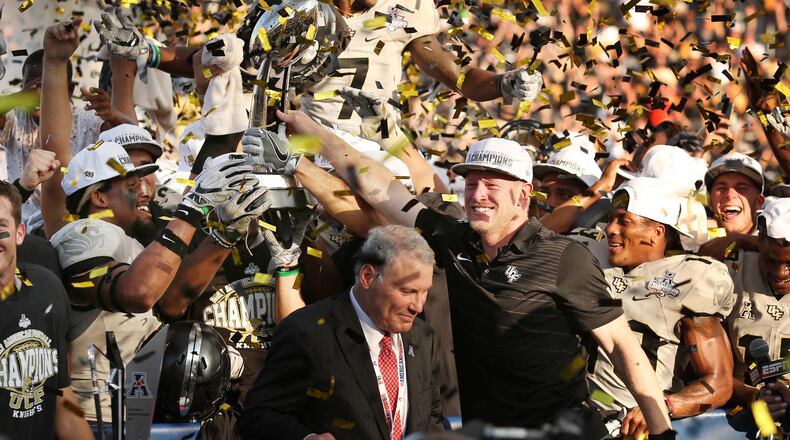 UCF head coach Scott Frost and players celebrate amid falling confetti with the championship trophy after winning the American Athletic Conference Championship Game at Spectrum Stadium Saturday, Dec. 2, 2017 in Orlando. UCF won the game and the AAC title 62-55 in double overtime. (Stephen M. Dowell/Orlando Sentinel)