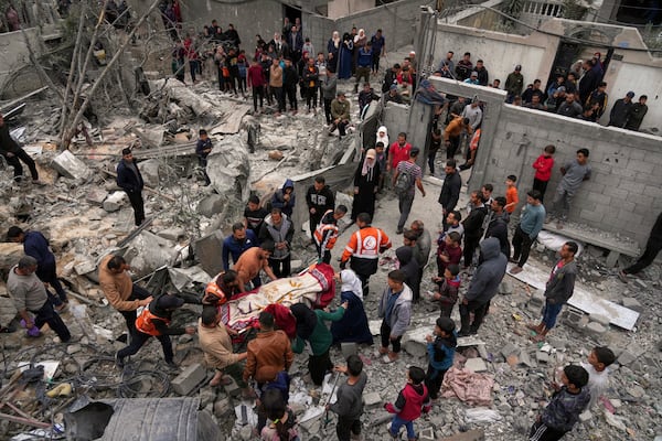 Volunteers and emergency workers remove a body from the rubble of the Manoun family's house after it was targeted by an Israeli army strike in Jabalia al-Balad, Gaza City, Sunday, April 13, 2025. (AP Photo/Jehad Alshrafi)