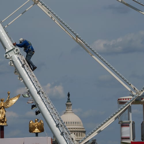 The U.S. Capitol is seen in the background of the ferris wheel as preparation continues for the Great American State Fair on the National Mall, Sunday, June 21, 2026, in Washington. (AP Photo/Jon Elswick