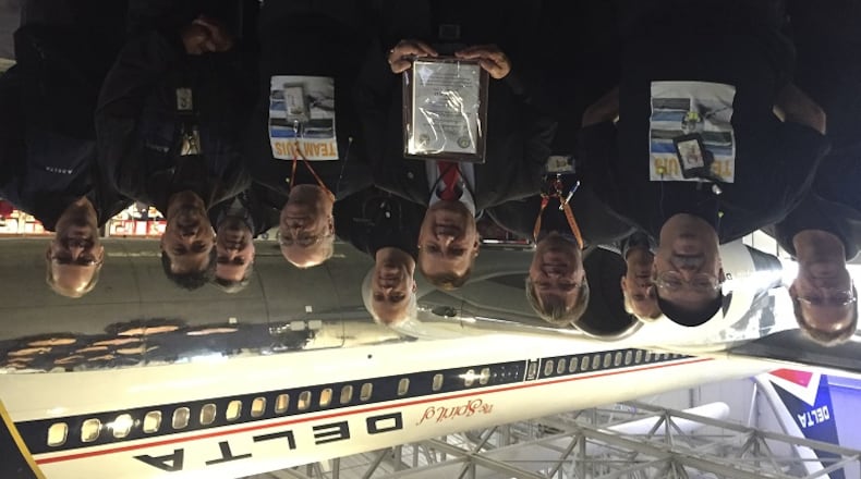 Luis Diaz of Marietta, center with plaque, received a prestigious lifetime achievement award for mechanics from the Federal Aviation Administration on Thursday. He posed with his former Delta Air Lines colleagues after the ceremony at the Delta Flight Museum. JEREMY REDMON/jredmon@ajc.com
