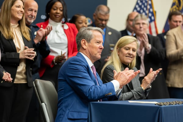 Gov. Brian Kemp, accompanied by first lady Marty Kemp, signed public safety bills at the Georgia Public Safety Training Center in Forsyth on Thursday.