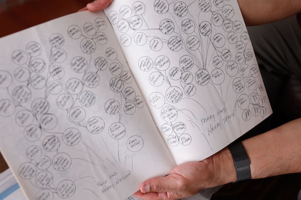 Ken Oglesby, the family historian of the Cloud-Travis family holds up a hand-written family tree passed down to him at his home in Alpharetta on Monday, June 30, 2025. (Natrice Miller/AJC)