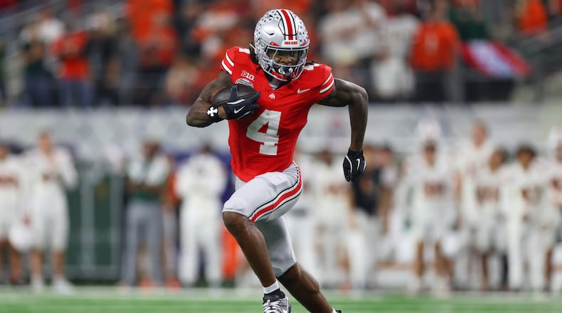 FILE - Ohio State wide receiver Jeremiah Smith runs the ball against Miami during the second half of the Cotton Bowl College Football Playoff quarterfinal game, Dec. 31, 2025, in Arlington, Texas. (AP Photo/Gareth Patterson, File)