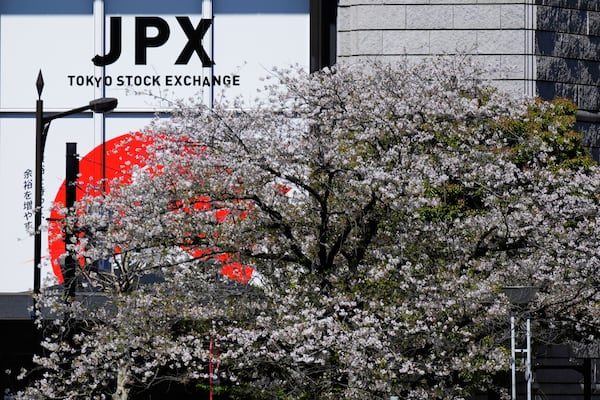 Cherry blossoms bloom across a street from the Tokyo Stock Exchange building in Tokyo, Wednesday, April 9, 2025. (AP Photo/Hiro Komae)