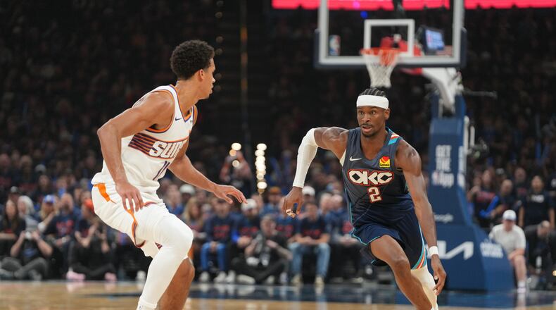Oklahoma City Thunder guard Shai Gilgeous-Alexander, right, drives past Phoenix Suns forward Oso Ighodaro during the second half in Game 2 of a first-round NBA playoffs basketball series Wednesday, April 22, 2026, in Oklahoma City. (AP Photo/Kyle Phillips)