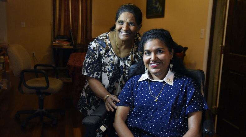 Pushpa Krishnaswamy, left, and her daughter, Kavita Krishnaswamy, a Ph.D. candidate in Computer Science at UMBC who is living with spinal muscular atrophy (SMA). Kavita is able to telecommute with Beam, a remote presence robot. (Kim Hairston/Baltimore Sun/TNS)