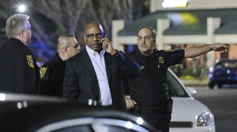 DeKalb Public Safety Director Cedric Alexander (center) speaks on the phone during Monday’s investigation. A DJ was shot and wounded early Monday, Mar. 3, 2014 during a shootout with police officers outside a popular DeKalb County nightclub, police said. The shooting happened outside the Velvet Room, a club in the 3300 block of Chamblee Tucker Road. The club was hosting an album release party Sunday night for Rick Ross and Sean “Diddy” Combs, according to the Velvet Room’s website. About 4 a.m., two off-duty officers working at the nightclub heard gunshots in the back of the club, according to DeKalb Public Safety Director Cedric Alexander. When the officers responded to the rear of the club, “one subject turned toward them, firing shots,” Alexander said. “They returned fire, hitting the subject in the leg.” The officers were uninjured, according to Alexander. He said the wounded man, who was identified to investigators as a disc jockey at the club, got up and went back inside the club, where he was arrested before being transported to Grady Memorial Hospital. “For whatever unknown reasons, it appears that this DJ who was involved in the shooting with some others turned and shot at the officers, and that’s when they returned fire,” Alexander said. He said the off-duty officers were in full uniform, and identified themselves as officers when they responded to the gunfire behind the club. “They were doing what they were trained to do,” Alexander told The Atlanta Journal-Constitution. JOHN SPINK/JSPINK@AJC.COM