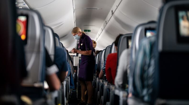 Flight attendants hand out refreshments to a packed Delta Air Lines flight on Friday, May 21, 2021. Delta is asking the U.S. Justice Department to create a national no-fly list of passengers who have been convicted for on-board disruptions. (Kent Nishimura/Los Angeles Times/TNS)