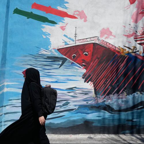A woman walks past a mural depicting a U.S. aircraft carrier under missile attack in downtown Tehran, Iran, Monday, June 8, 2026. (AP Photo/Vahid Salemi)