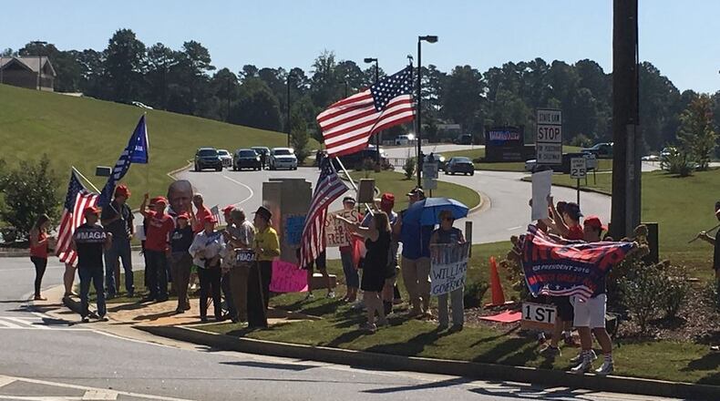 A group of protesters has gathered near River Ridge High School in Cherokee County. ELLEN ELDRIDGE / ELLEN.ELDRIDGE@AJC.COM