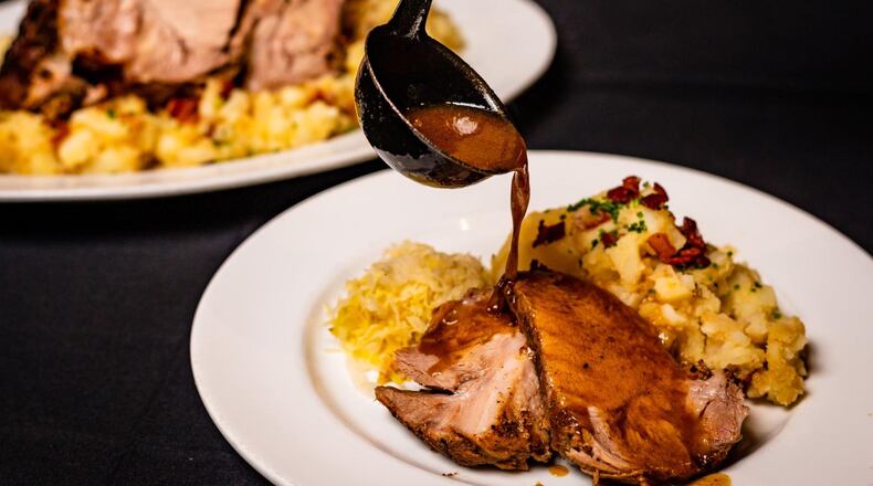 Schweinebrate prepared by Brad Parker, executive chef of Dantanna’s Buckhead. On the front plate, it’s shown with sauerkraut and German potato salad. STYLING BY BRAD PARKER / CONTRIBUTED BY HENRI HOLLIS