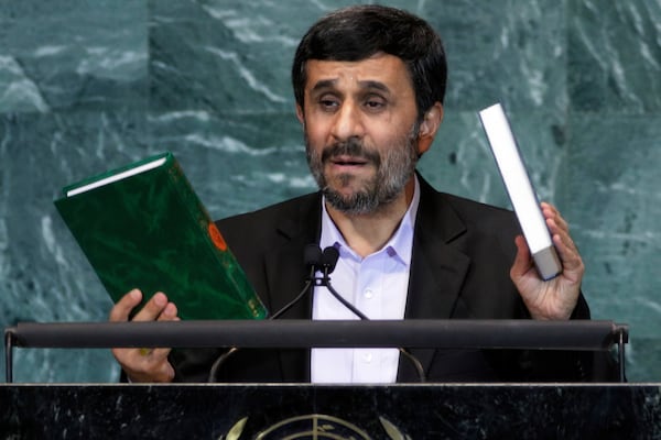 FILE - Iran's President Mahmoud Ahmadinejad, President of Iran, holds up a copies of the Quran, left, and Bible, right, as he addresses the 65th session of the United Nations General Assembly at U.N. headquarters, Sept. 23, 2010, during a speech where he prompted walkouts from the assembly when he questioned whether the Sept. 11 attacks were staged. (AP Photo/Richard Drew, File)