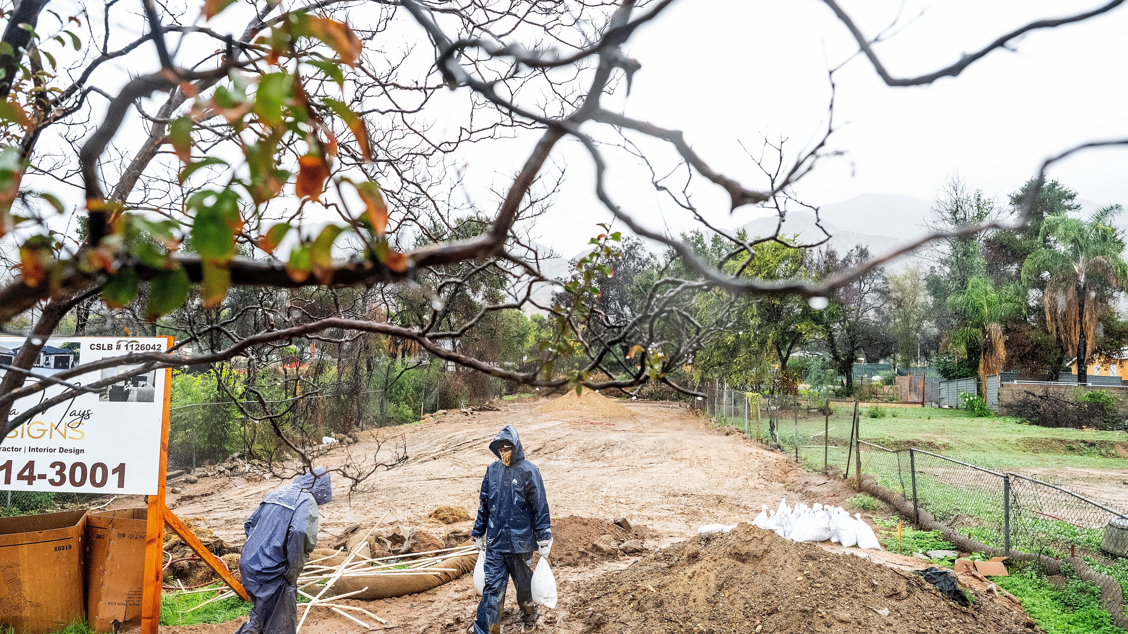 James Jones carries sandbags while trying to prevent water from running off a property scorched in the Eaton Fire in Altadena, Calif., as the region remains under flash flood warnings on Saturday, Nov. 15, 2025. (AP Photo/Noah Berger)