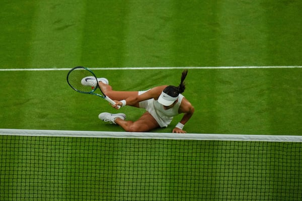 Emma Raducanu of Britain slips and falls attempting to return to Aryna Sabalenka of Belarus during a third round women's singles match at the Wimbledon Tennis Championships in London, Friday, July 4, 2025. (AP Photo/Joanna Chan)