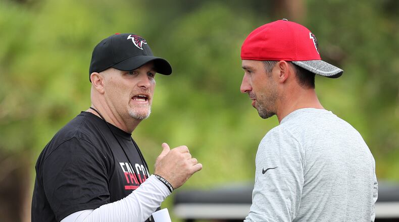 072816 FLOWERY BRANCH: Falcons head coach Dan Quinn confers with offensive coordinator Kyle Shanahan during the first day of training camp on Thursday, July 28, 2016, in Flowery Branch. Curtis Compton /ccompton@ajc.com