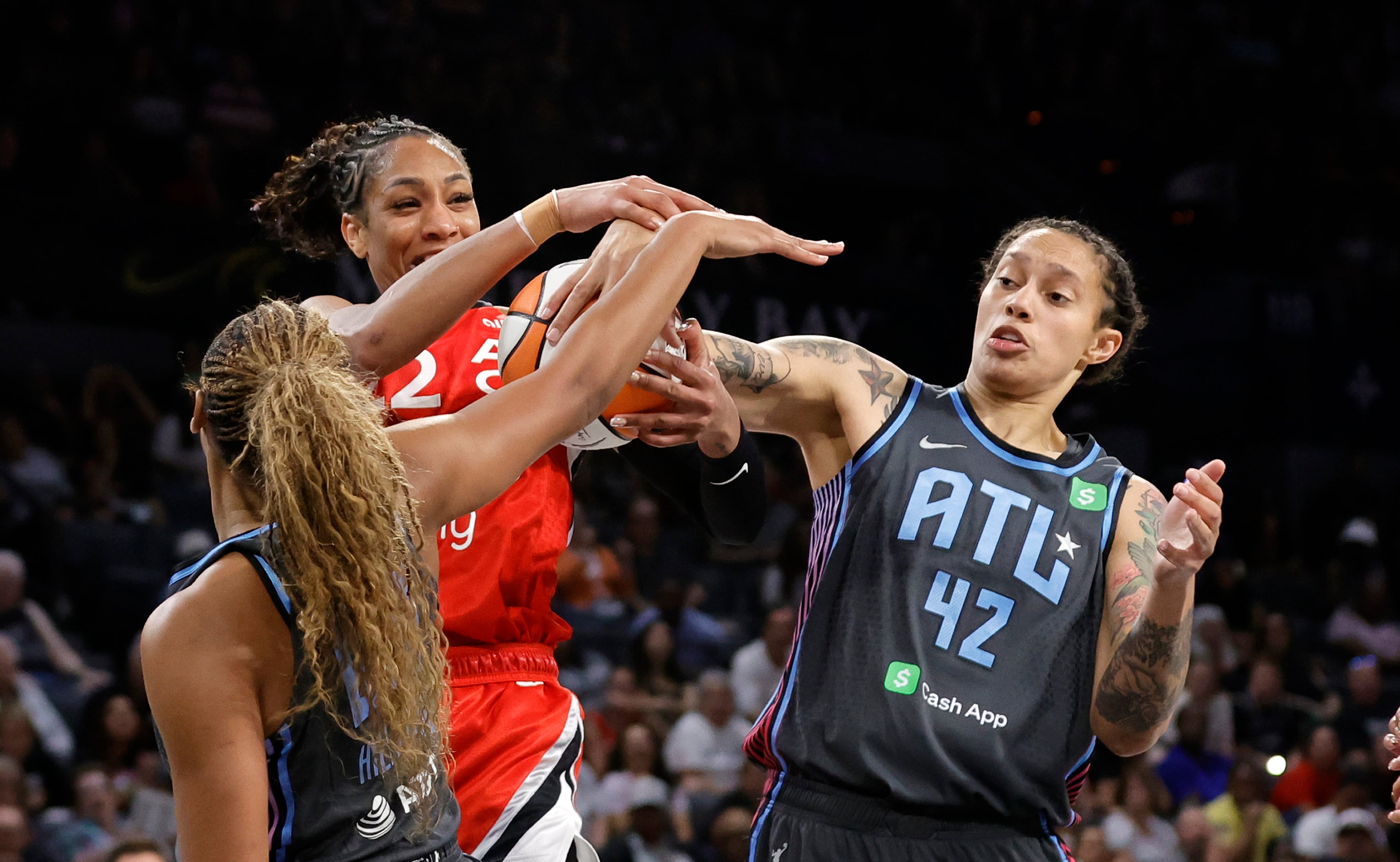 Aces center A'ja Wilson (center) and Dream center Brittney Griner (right) fight for a rebound as Dream forward Naz Hillmon approaches on Tuesday, July 22, 2025, in Las Vegas. (Steve Marcus/Las Vegas Sun via AP)
